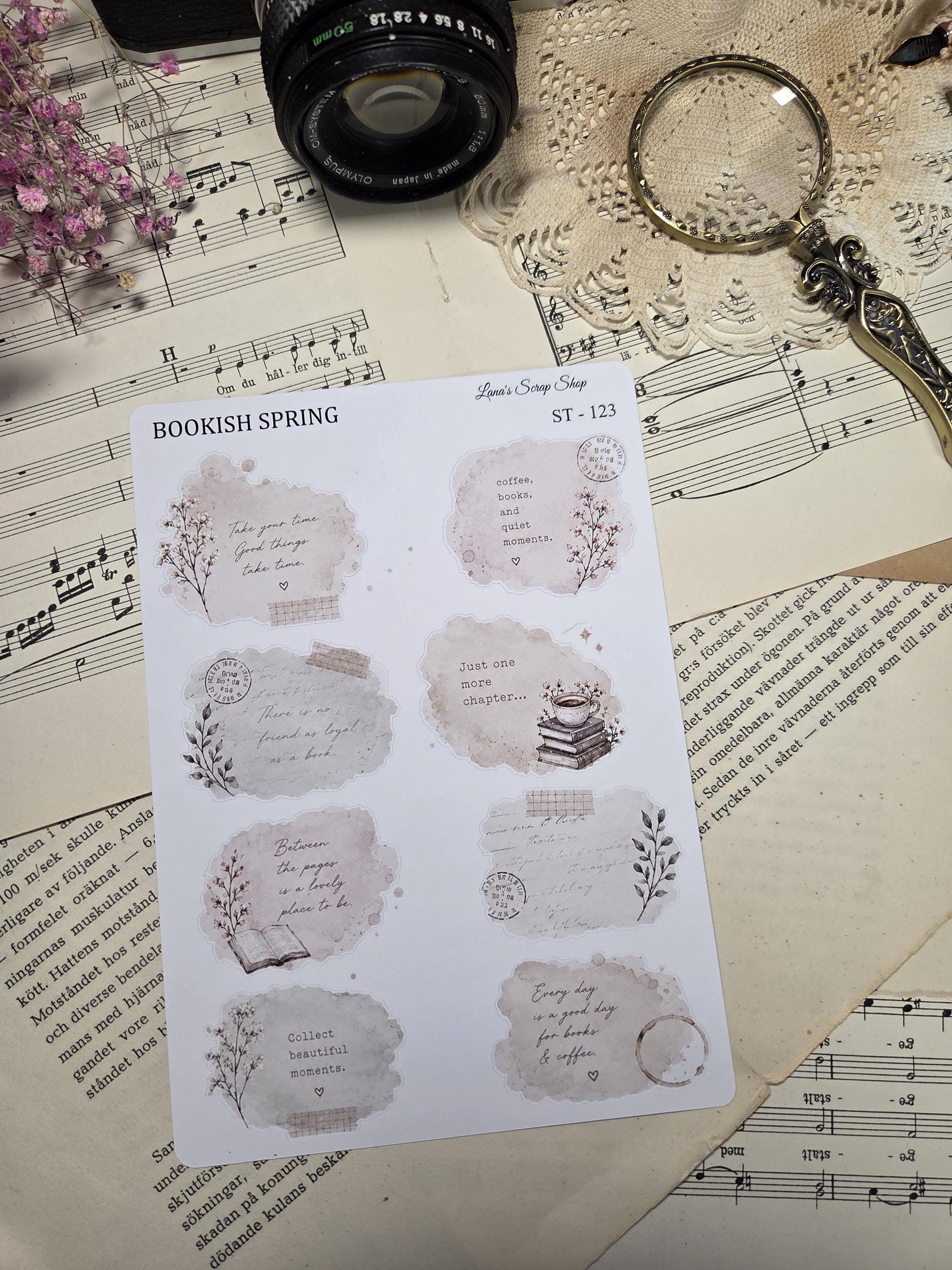 A sheet of decorative stickers with a "Bookish Spring" theme. The stickers feature watercolor-style designs with quotes about books, coffee, and quiet moments. The colour palette includes beige, brown, and floral elements.