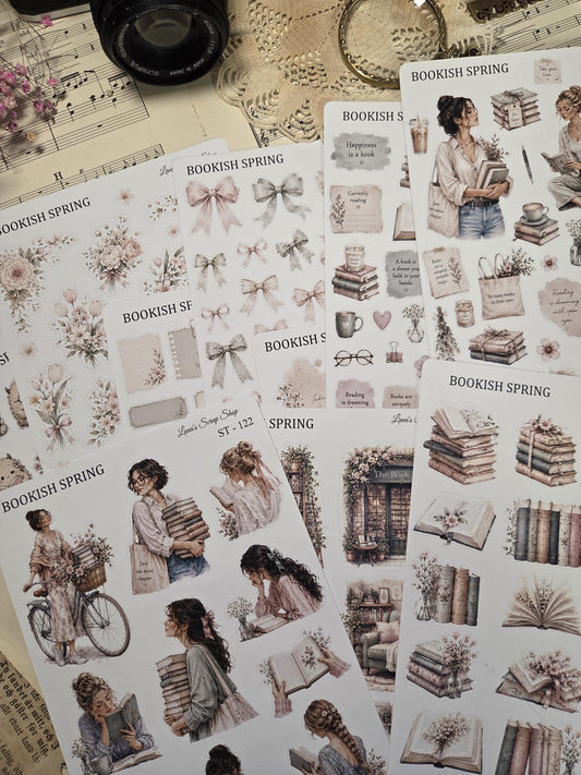 A selection of "Bookish Spring" sticker sheets. The stickers depict books, bows, floral designs, and women reading. The colour scheme includes soft pinks, creams, and browns.
