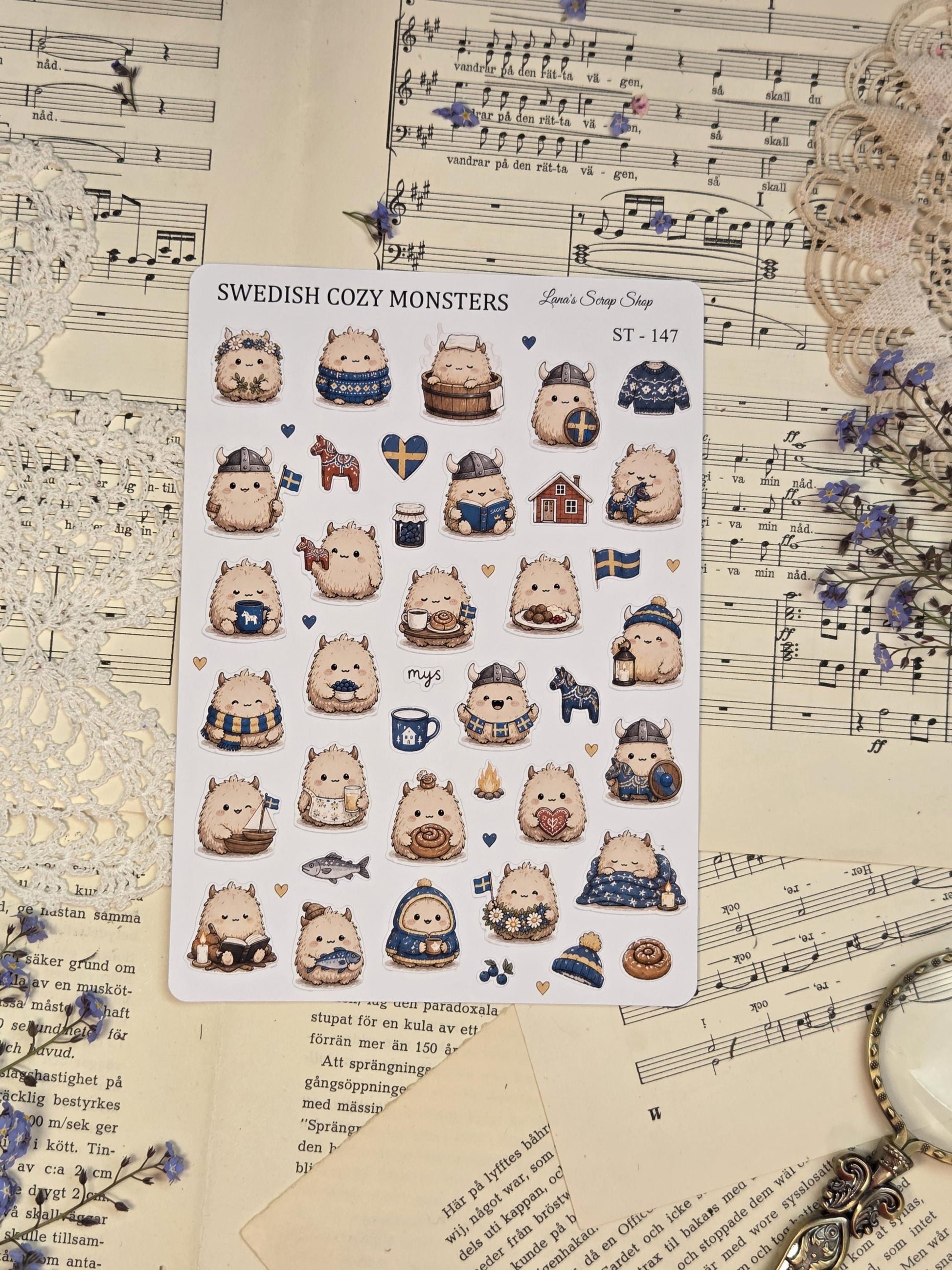 Adorable cozy monster stickers inspired by Swedish fika and hygge culture with fluffy creatures, coffee, candles, sweaters, lanterns, and Scandinavian blue tones.